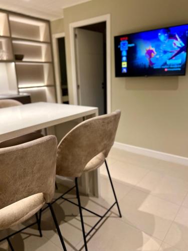 a room with a table and chairs with a tv on the wall at Soñado Departamento en B Jardin in Cordoba