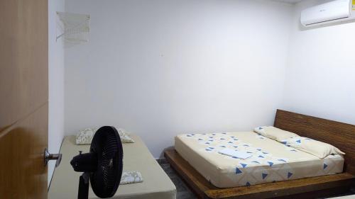 a bedroom with a bed and a fan next to a door at Villa Paradise - Mar y Naturaleza in Punta de Piedra