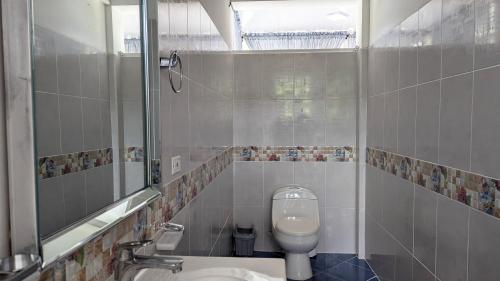 a bathroom with a toilet and a sink and a mirror at Villa Paradise - Mar y Naturaleza in Punta de Piedra