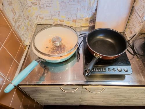 a pot and a pan sitting on a stove at アワセベイストリートホテル in Okinawa City