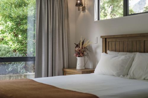 um quarto com uma cama e uma janela e um vaso com flores em Redfern Retreat em Queenstown