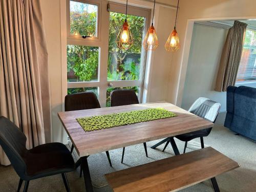 a dining room with a wooden table and chairs at Home with spa, sauna, garden in prime location in Rotorua