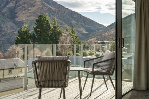 uma varanda com mesa, cadeiras e montanhas em Redfern Retreat em Queenstown
