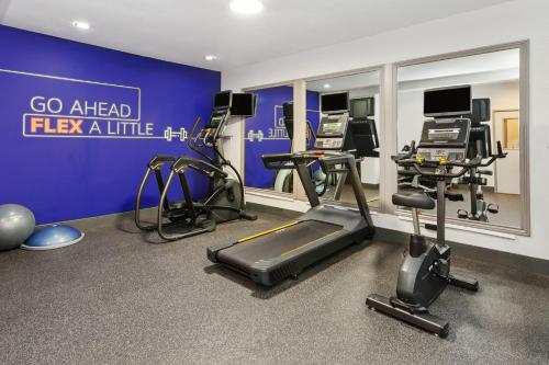 a gym with exercise equipment and a blue wall at Holiday Inn Express & Suites Carmel North – Westfield by IHG in Carmel