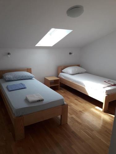 a bedroom with two beds and a skylight at Comfortable apartment with the view in Njivice