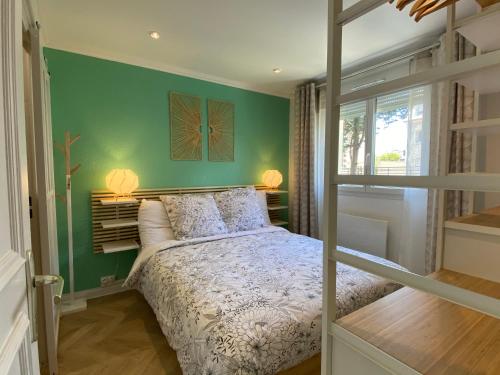 une chambre avec un lit et un mur végétal dans l'établissement Chaleureux deux pièce coeur de ville avec parking privé, à Cabourg