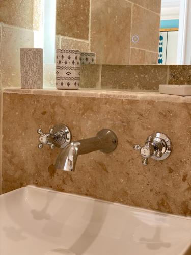 La salle de bains est pourvue d'un lavabo et d'une baignoire avec un robinet. dans l'établissement Cosy deux pièces coeur de ville avec parking privé, à Cabourg