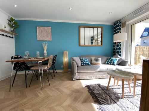 un salon avec un canapé et une table dans l'établissement Cosy deux pièces coeur de ville avec parking privé, à Cabourg