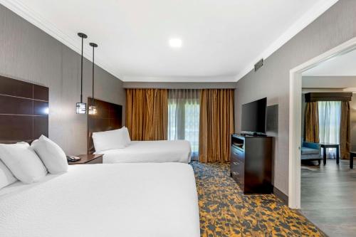 a hotel room with two beds and a television at Best Western Brentwood in Brentwood