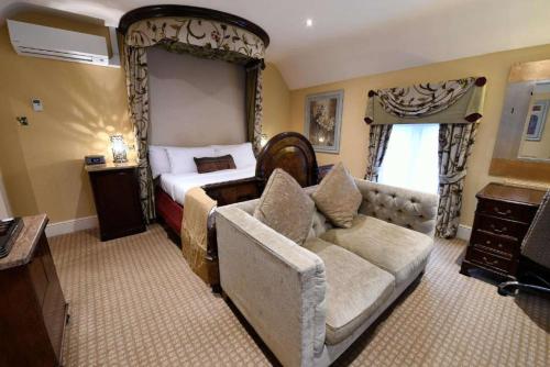 a bedroom with a bed and a couch in a room at Best Western Premier Doncaster Mount Pleasant Hotel in Doncaster