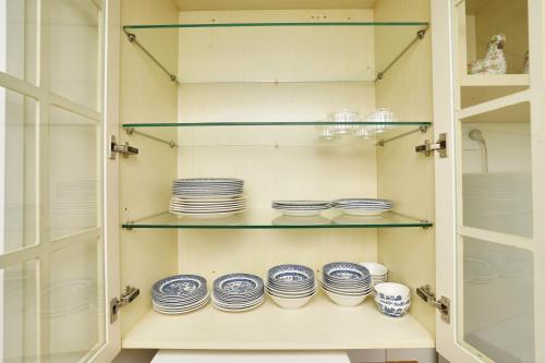 a pantry with blue and white dishes on shelves at Narrows Hideaway - Bookahome in Rukuhia