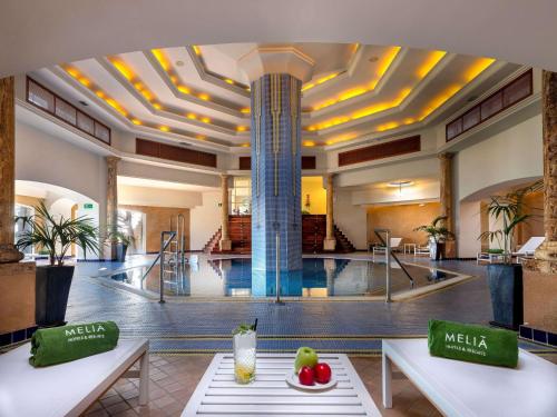 a lobby with a pool in the middle of a building at Meliá Isla Canela in Isla Canela