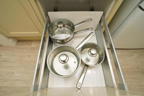 a kitchen with two pots and pans on a shelf at Narrows Hideaway - Bookahome in Rukuhia
