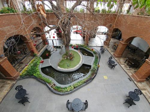 an overhead view of a garden with a tree and a pond at Punto Madero Hotel & Plaza in Mocorito