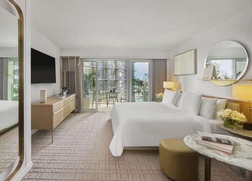 a hotel room with a large white bed and a balcony at Fairmont Century Plaza Los Angeles at Beverly Hills in Los Angeles