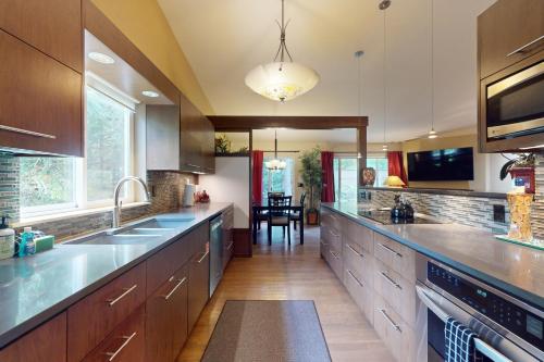 a large kitchen with wooden cabinets and stainless steel appliances at Forest Retreat in Shoreline