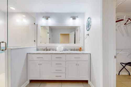 un bagno bianco con lavandino e specchio di Ocean view 'Atlantic dream' w/pool & spa, wraparound balcony, steps to beach a Butler Beach