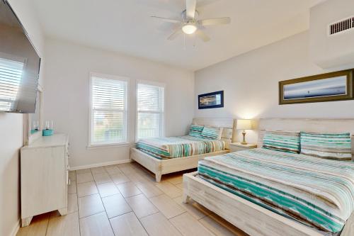 una camera da letto con due letti e un ventilatore a soffitto di Ocean view 'Atlantic dream' w/pool & spa, wraparound balcony, steps to beach a Butler Beach