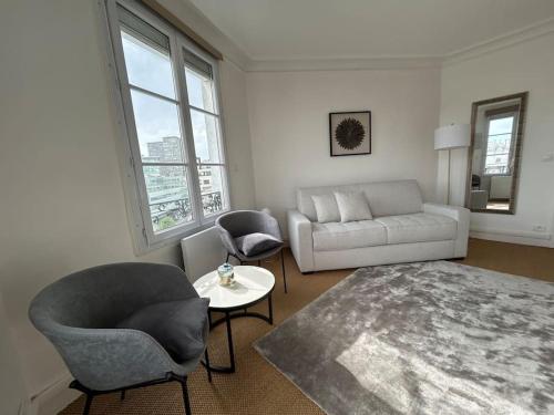un salon avec un canapé et une table dans l'établissement Elegant Eiffel tower view flat, à Paris