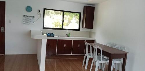 eine Küche mit Tisch und Spüle und Fenster in der Unterkunft Soul Shine Beach House in Bacungan