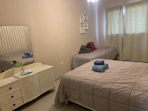 a small bedroom with two beds and a mirror at Confort urbano. Alójate en el corazón de Rosario in Rosario