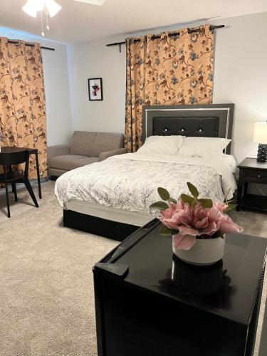 a bedroom with a bed and a table with a flower on it at Cozy Suite with Private Patio Close to Downtown and UC Davis Medical Center in Sacramento