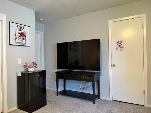 a room with a flat screen tv and a table with a table sidx sidx sidx at Cozy Suite with Private Patio Close to Downtown and UC Davis Medical Center in Sacramento