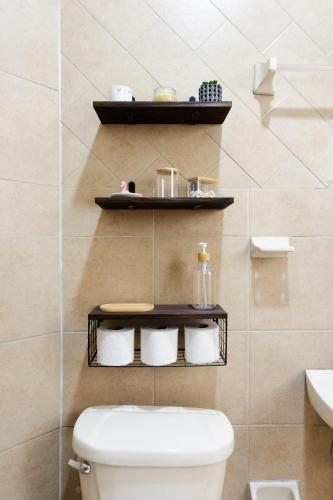 a bathroom with a toilet and a shelf on the wall at Casa Cataleya Refugio Bohemio y Romántico en Oaxaca in Oaxaca City