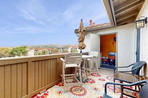 a balcony with a table and chairs and an umbrella at Monarch Vista in Dana Point