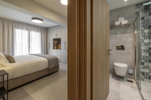 a bedroom with a bed and a shower and a toilet at AM Suites Kefalonia in Argostoli