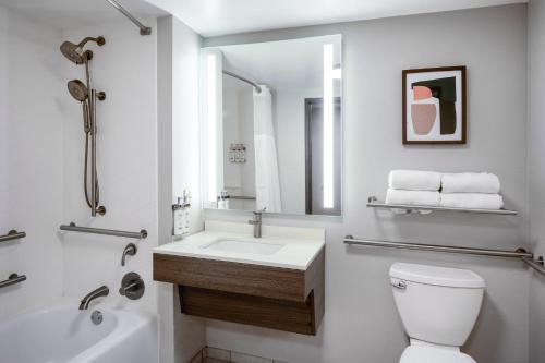 a bathroom with a sink and a toilet and a mirror at Holiday Inn Blytheville by IHG in Blytheville
