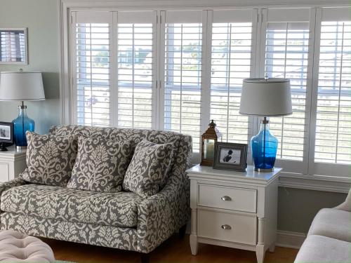 a living room with a couch and two tables with lamps at Watch Hill, RI Luxury Penthouse Rental Ocean View & Rooftop Deck in Westerly
