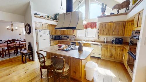 a kitchen with wooden cabinets and a table and chairs at Thornes Downtown Delight - WiFi - Satellite - Washer - Dryer - Fireplace - Fenced In Back Yard in Red River