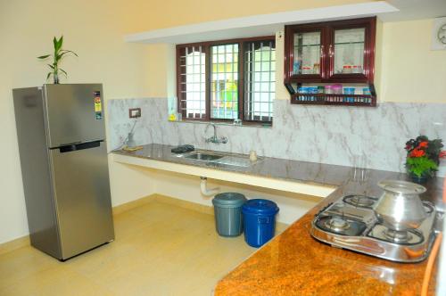 a kitchen with a stainless steel refrigerator and a counter at Grace Guest Home in Trichūr