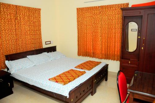um quarto com uma cama, uma cómoda e um espelho em Grace Guest Home em Thrissur