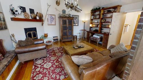 a living room with leather furniture and a fireplace at Thornes Downtown Delight - WiFi - Satellite - Washer - Dryer - Fireplace - Fenced In Back Yard in Red River