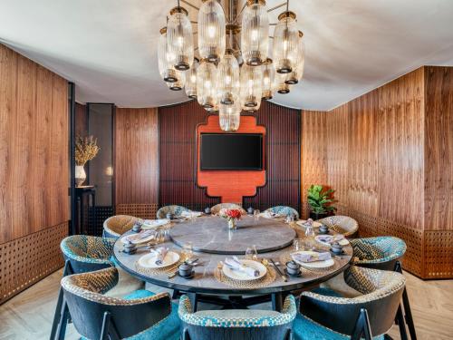 a dining room with a table and chairs and a tv at InterContinental Chiang Mai The Mae Ping in Chiang Mai