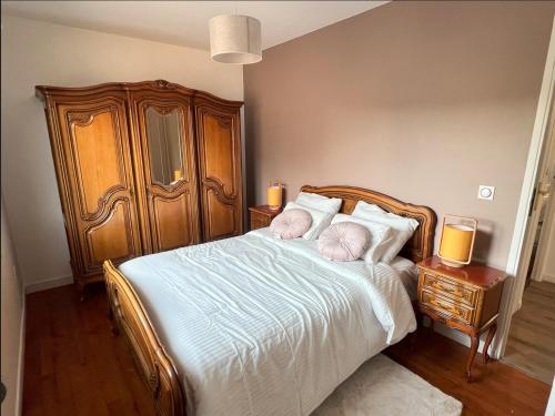 a bedroom with a bed with white sheets and two lamps at Belle maison avec jardin ! in Bezannes-les-Reims