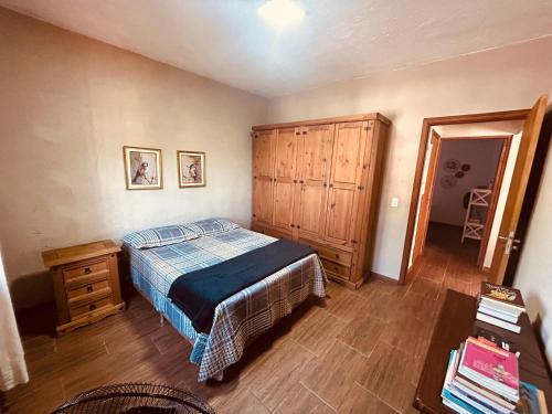 a bedroom with a bed and a wooden cabinet at Casa Flor de Lis in Águas de São Pedro