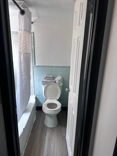 a bathroom with a toilet and a bath tub at Glenstone place extended stay motel in Springfield