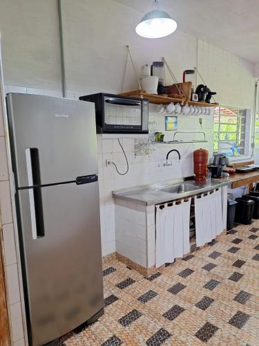 a kitchen with a refrigerator and a sink at Down The River Hostel in Iporanga