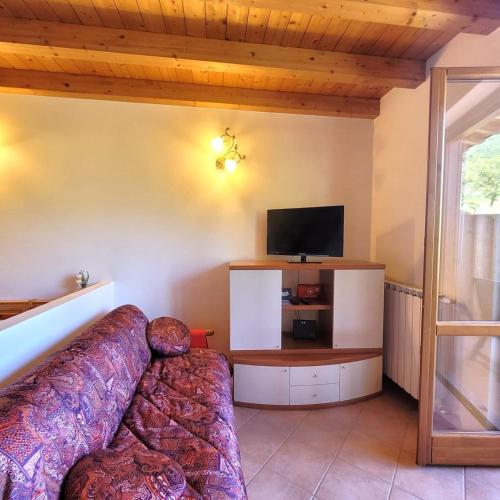 a living room with a couch and a flat screen tv at Mountain Lake Endine- Iseo Milly's Home in Bianzano