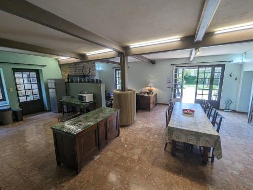 un salon avec une table et une cuisine dans l'établissement Villa spacieuse avec jardin privé, proche vignobles et lacs – 4 chambres, cheminée, équipement bébé - FR-1-611-27, à Vaux-sous-Aubigny