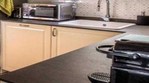 a kitchen with a sink and a microwave on a counter at New Villa Es Novells Illes Balears in Illes Balears