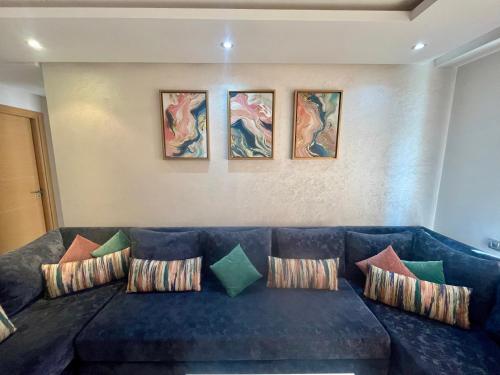 a living room with a blue couch with pillows at Zen & Welcoming CFC - Garage & Tramway in Casablanca