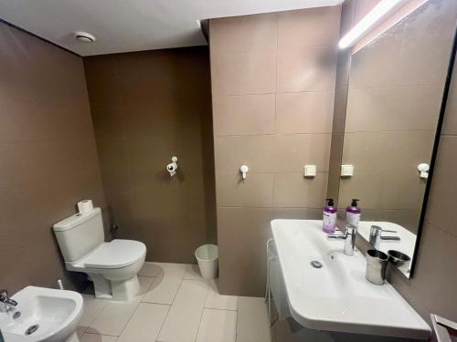a bathroom with a sink and a toilet and a mirror at Zen & Welcoming CFC - Garage & Tramway in Casablanca