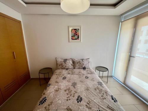 a bedroom with a bed and two stools at Zen & Welcoming CFC - Garage & Tramway in Casablanca