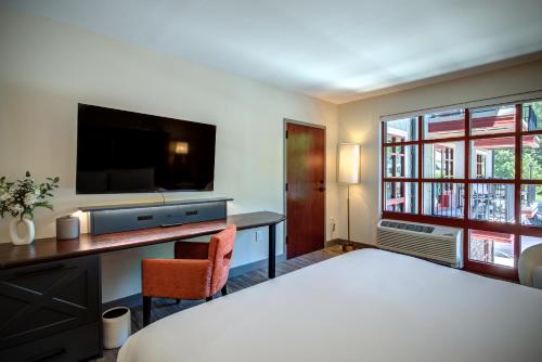 a hotel room with a bed and a desk and a tv at The Embers Hotel in Blowing Rock
