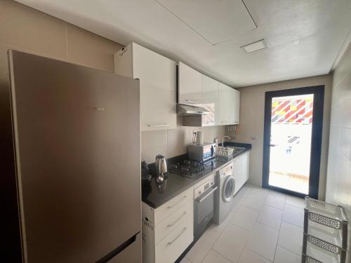 a kitchen with a refrigerator and a stove top oven at Zen & Welcoming CFC - Garage & Tramway in Casablanca