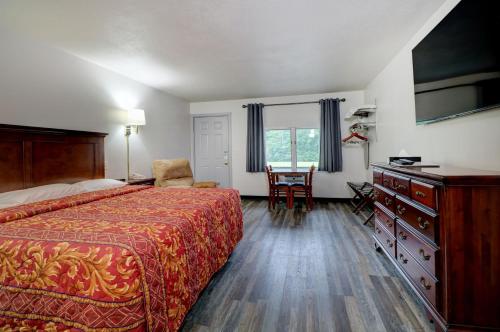 a hotel room with a bed and a table with a chair at Canaan Motel in Canaan